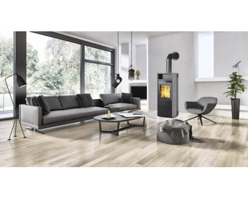 Moderner Wohnraum mit Kaminofen, großem Sofa, Sessel und Parkettboden in heller und offener Gestaltung.