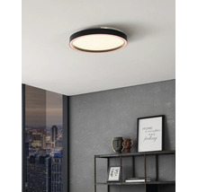 Flache, runde LED-Deckenleuchte in Schwarz an weißer Zimmerdecke in modernem Ambiente mit grauer Wand und Metallregal.
