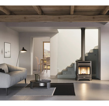 Moderner Kaminofen mit Sichtscheibe und langem Ofenrohr in einem hellen Wohnzimmer mit Sofa, Couchtisch und Holzdecke.