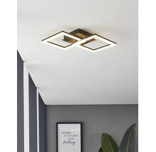 Moderne schwarze LED-Deckenleuchte mit zwei ineinandergreifenden quadratischen Lichtrahmen in einem modern eingerichteten Raum.