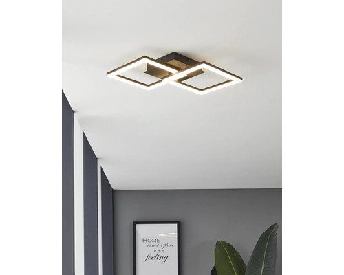 Moderne schwarze LED-Deckenleuchte mit zwei ineinandergreifenden quadratischen Lichtrahmen in einem modern eingerichteten Raum.