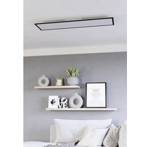 Moderne rechteckige LED-Deckenleuchte mit schwarzem Rahmen montiert über Wandregalen in einem hellen Wohnzimmer.