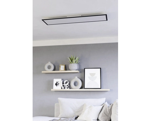 Moderne rechteckige LED-Deckenleuchte mit schwarzem Rahmen montiert über Wandregalen in einem hellen Wohnzimmer.