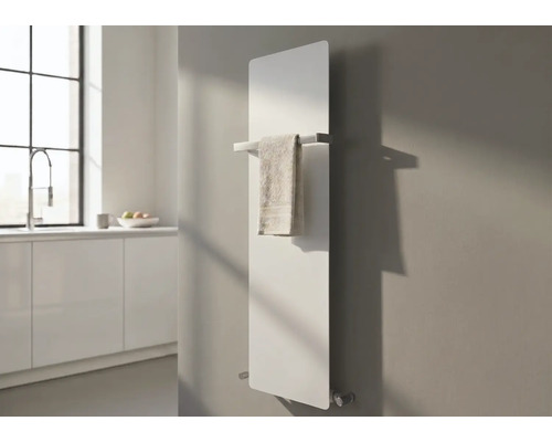 Moderner vertikaler Flachheizkörper an einer Wand mit silberner Handtuchstange und Handtuch in einer hellen, minimalistischen Küche.