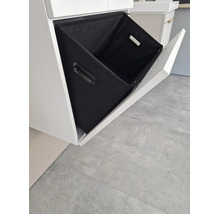 Badezimmerunterschrank mit offenem, schrägem Auszug und einem schwarzen Textilkorb.
