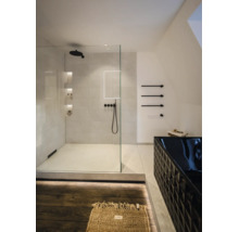 Modernes, helles Badezimmer mit begehbarer Glasdusche, schwarzen Armaturen und einer strukturierten schwarzen Badewanne.