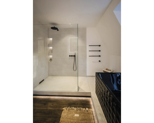 Modernes, helles Badezimmer mit begehbarer Glasdusche, schwarzen Armaturen und einer strukturierten schwarzen Badewanne.
