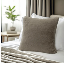 Quadratisches Dekokissen aus weichem Kunstfell in Taupe, platziert auf einem Bett mit weißer Bettwäsche.