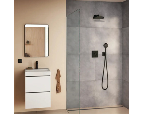 Modernes Badezimmer mit weißem Waschbeckenunterschrank, beleuchtetem Wandspiegel und einer offenen Walk-in Dusche mit grauen Fliesen.