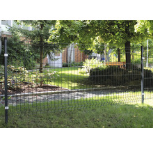 Stabmattenzaun aus Metall in einem Garten mit Pfosten und Befestigungselementen vor einer Grünfläche mit Bäumen und Hauswand