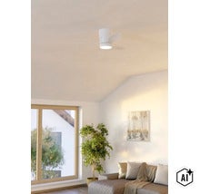 Moderner Deckenventilator mit integrierter LED Beleuchtung in einem hellen Wohnzimmer mit Sitzbereich und Zimmerpflanze. (Image AI modified or generated)