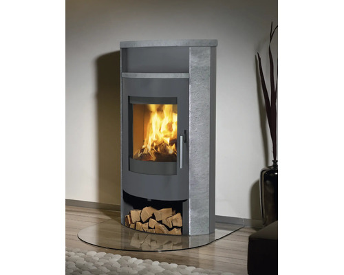 Moderner Kaminofen mit Specksteinverkleidung und brennendem Feuer hinter einer Glasscheibe sowie integriertem Holzfach.