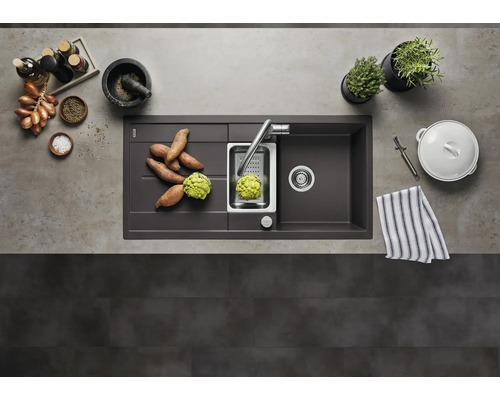 Moderne Küchenspüle aus Verbundwerkstoff mit Abtropffläche, Edelstahlbecken und Armatur in einer organisierten Küche mit Lebensmitteln von oben.