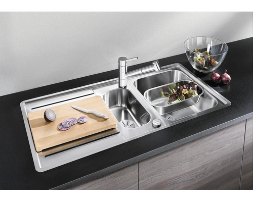 Edelstahl Einbauspüle mit zwei Becken, Armatur, Schneidebrett und Zubehör in moderner Küche.