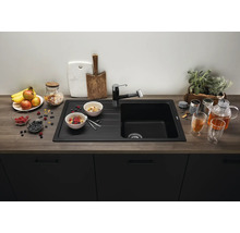 Moderne schwarze Einbauspüle mit Abtropffläche und passender Armatur in einer Küche mit Arbeitsplatte in Holzoptik und dunklen Küchenfronten.