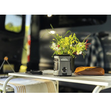 Thermacell Mückenschutzgerät auf einem Camping-Tisch vor einem Wohnmobil im Freien.
