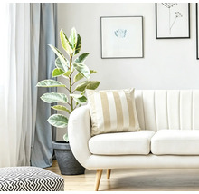 Helles Wohnzimmer mit Sofa gestreiftem Kissen und Zimmerpflanze in einem Pflanzkübel.