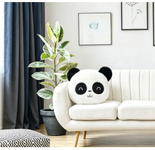Ein flauschiges Panda Kissen auf einem modernen hellen Sofa in einem Wohnzimmer mit Zimmerpflanze und Wandbildern.