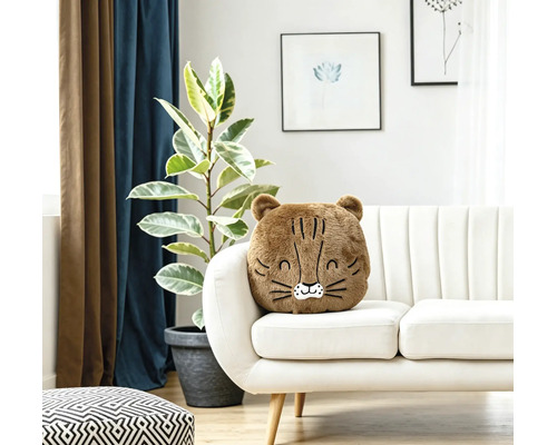 Ein weiches, flauschiges Dekokissen in Tierform liegt auf einem hellen Sofa in einem modern eingerichteten Wohnzimmer mit Zimmerpflanze.