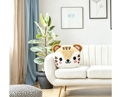 Ein weiches Plüschkissen in Tierform in Form eines Tigers sitzt auf einem modernen weißen Sofa in einem hellen und stilvoll eingerichteten Wohnraum.