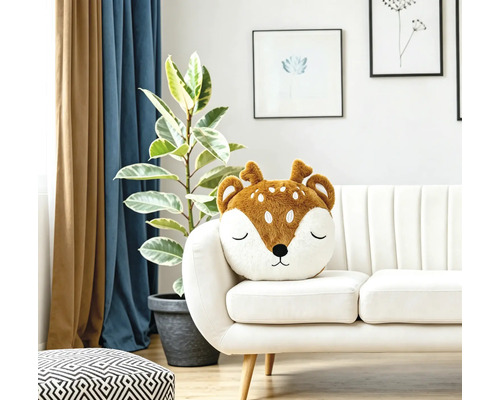 Ein weiches Dekokissen in Form eines Rehkopfes auf einem hellen Sofa in einem modern eingerichteten Wohnzimmer.