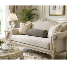 Klassisches Sofa mit geschnitztem Holzrahmen und Zierkissen in einem elegant eingerichteten Wohnzimmer.