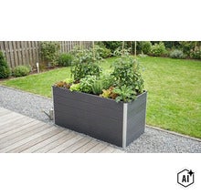 Rechteckiges Hochbeet aus Kunststoff mit Tomaten und Kräutern bepflanzt auf einer Holzterrasse im Garten. (Image AI modified or generated)