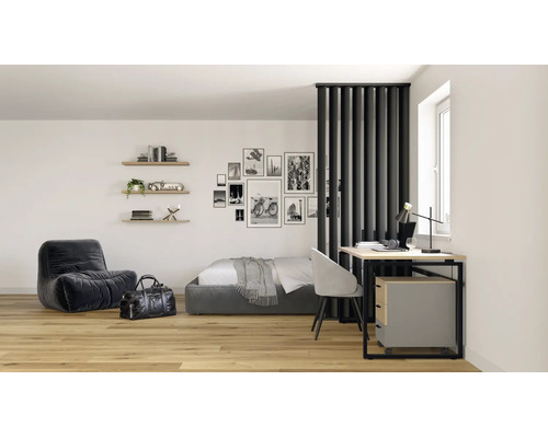 Modernes Studio Apartment mit Raumteiler aus Lamellen, Holzboden, Bett, Lounge Sessel und Schreibtisch mit Rollcontainer.