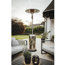 Ein Terrassenstrahler aus Edelstahl auf einer Steinterrasse mit Loungemöbeln in einem Garten.