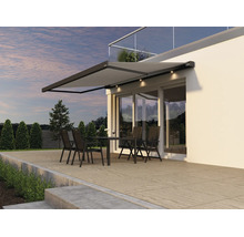 Moderne Terrassenmarkise mit integrierter LED Beleuchtung über einer Terrasse mit Sitzgruppe vor einem modernen Wohnhaus.