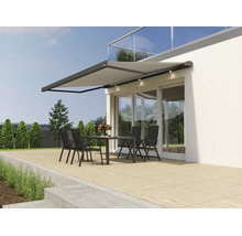 Moderne Gelenkarmmarkise mit integrierter LED Beleuchtung montiert an einer Hausfassade über einer Terrasse mit Sitzgruppe