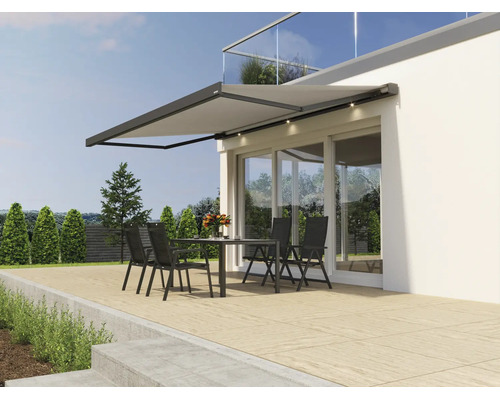 Moderne Gelenkarmmarkise mit integrierter LED Beleuchtung montiert an einer Hausfassade über einer Terrasse mit Sitzgruppe