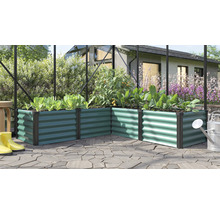 Winkel Hochbeet aus gewelltem Metall in einem Gewächshaus mit Pflanzen und Gießkanne auf einer Terrasse.