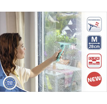 Eine Frau reinigt ein Fenster mit einem Fensterabzieher, der eine Arbeitsbreite von 28 Zentimetern hat und ein Klicksystem besitzt.