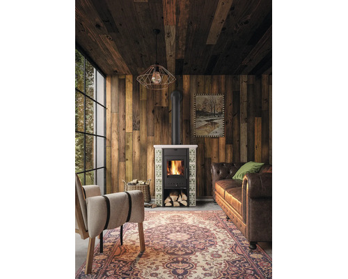 Ein moderner Kaminofen mit Kachelverkleidung in einem gemütlichen Wohnzimmer mit Holzvertäfelung, Ledersofa, Sessel und Teppich.