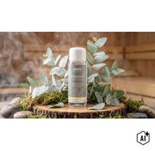Weka Sauna Aufguss Konzentrat Eukalyptus in 250 Milliliter Flasche mit Eukalyptuszweigen auf einer Baumscheibe in der Sauna (Image AI modified or generated)