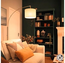 Moderne Bogenlampe mit Stoffschirm neben einem Sofa in einem gemütlich eingerichteten Wohnzimmer mit dunklem Regal und Kamin. (Image AI modified or generated)