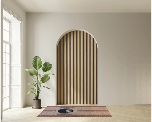 Wohnraum mit einer bogenförmigen Wandnische verkleidet mit Holzlamellen sowie einer Zimmerpflanze und einem gemusterten Läufer auf Parkettboden.