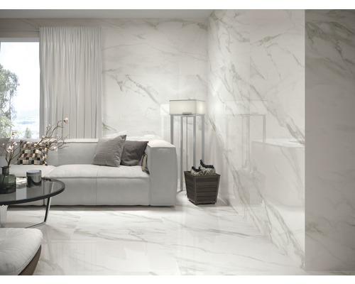 Heller Wohnraum mit Sofa, Lampe und Fliesen in Marmoroptik an Boden und Wand