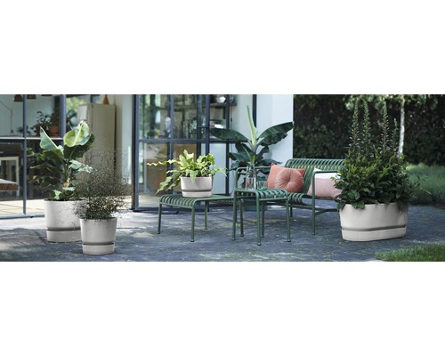 Außenbereich mit Pflanzen in Pflanzgefäßen auf einer Terrasse mit Sitzgelegenheiten.