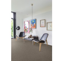 Wohnzimmer mit Teppichboden, zwei Stühlen und dekorativen Elementen