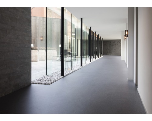 Langer Flur mit Glaswand zum Innenhof und Bodenbelag