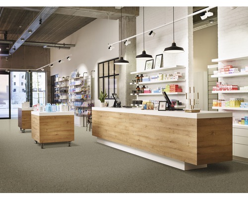 Innenansicht einer hellen Apotheke mit Verkaufstresen, Regalen und Produkten