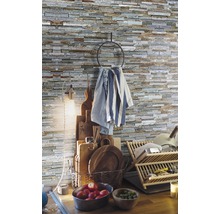 Küchenszene mit Dekosteinen an der Wand, Geschirrtuchhalter, Schneidebrettern, Geschirrkorb und frischem Obst