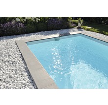 Schwimmbad mit grauen Fliesen und weißen Kieselsteinen im Garten
