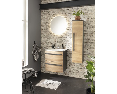 Badezimmer mit Waschtisch, Spiegel, Hochschrank und Dekoration vor Steinwand