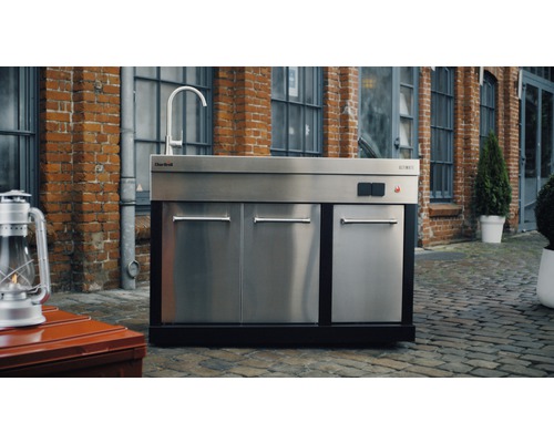 Outdoor-Küche mit Spüle, Schränken und Wasserhahn vor Backsteingebäude