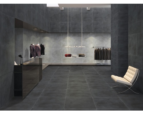 Große graue Fliesen in einem Bekleidungsgeschäft mit Kleidung und Stuhl