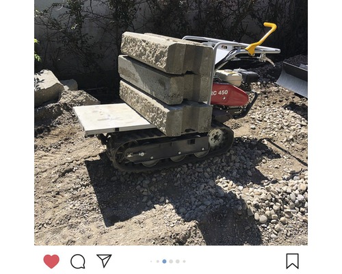 Raupentransporter mit Betonsteinen auf einer Baustelle
