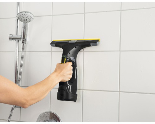Hand benutzt Fenstersauger an Badezimmerwandfliesen